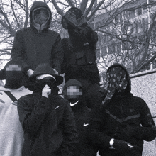 a black and white photo of a group of people wearing hoodies and nike jackets