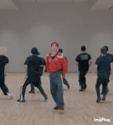 a group of young men are dancing in a room with the word imgplay visible in the corner