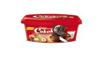 a cat is sitting on top of a container of cocok spread .