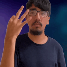 a man with glasses and a beard is giving a middle finger