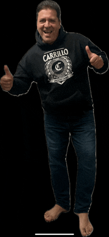 a man wearing a black carrillo hoodie giving a thumbs up