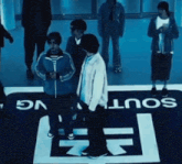 a group of people standing in front of a south vg logo