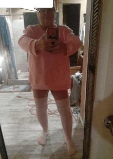 a woman takes a selfie in front of a mirror