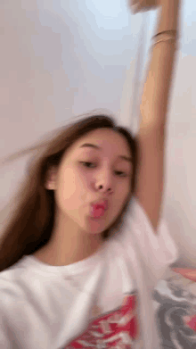 a blurry picture of a woman making a funny face with her hand in the air .