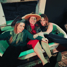 three women are sitting in a bathtub with their legs crossed