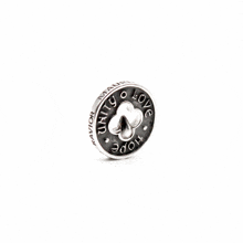 a silver coin with a clover and the words " united love hope " on it