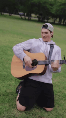 a man is kneeling down playing a guitar