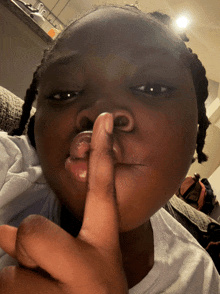 a little girl is making a shhh sign with her finger to her mouth