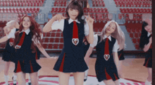 a group of girls in school uniforms are dancing on a court .