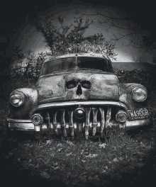 a black and white photo of an old car with a skull on the front grille .