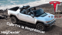 a white tesla truck is parked on a rocky hillside