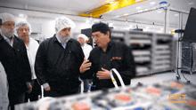 a group of men are looking at a piece of equipment with ast written on the bottom