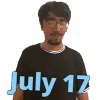 a man wearing glasses and a black shirt with the words july 17 on it