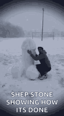 a man is kneeling down next to a snowman with the words `` shep stone showing how it 's done '' .