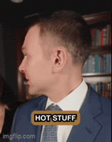 a man in a suit and tie has a hot stuff sticker on his chest
