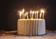 a birthday cake with sparklers on it and a black background