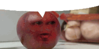 a red apple with a face on it sits on a table