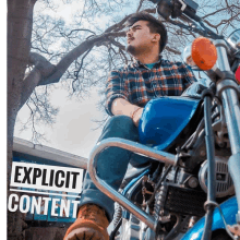 a man is sitting on a blue motorcycle with explicit content written on the bottom