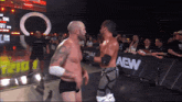 two men are wrestling in front of a aew barrier
