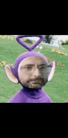 a man in a purple teletubbies costume with a heart on his head