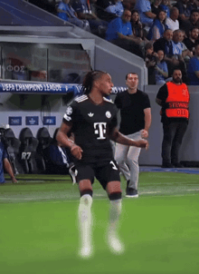 a soccer player in a black t-mobile jersey runs on the field