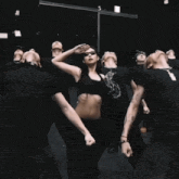 a woman in a crop top is dancing with a group of people