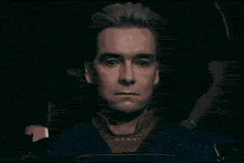 a close up of a man 's face with a serious look on his face in a dark room .