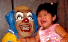 a little girl is crying while holding a clown .