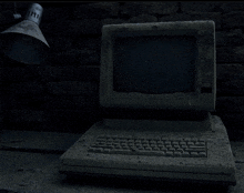 an old computer is sitting on a table next to a lamp which says ' ii ' on it