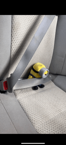 a stuffed minion is sitting in a car seat