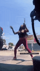 a woman is dancing in front of a gas pump and a sign that says " streamcitycinderella " on it