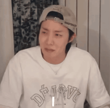 a man wearing a baseball cap and a white shirt with the word daiv on it
