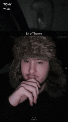 a man wearing a fur hat has lit off henny written on the bottom