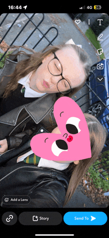 a phone screen shows a picture of two girls with a pink heart in front of their faces