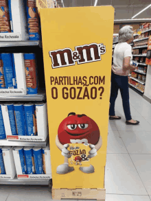 a m & m 's display in a store with a woman standing behind it