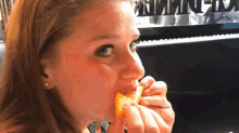 a woman is eating a piece of food in front of a piano with the word piano on the keyboard