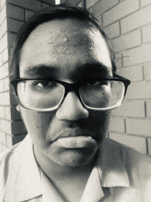 a man wearing glasses is making a funny face in a black and white photo