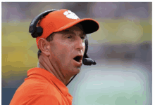 a man wearing a clemson hat and a headset