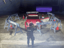 a police officer stands in front of a do not cross sign in front of a car