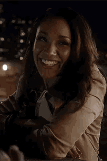 a woman is smiling at the camera while sitting at a table .