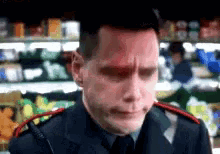 a man in a uniform with a red spot on his forehead stands in front of a grocery store shelf