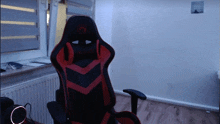 a red and black gaming chair with a logo on the back