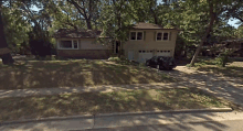 a black suv is parked in front of a house on a sunny day