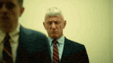 a man in a suit and tie is looking down