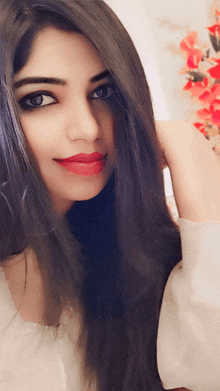 a close up of a woman 's face with a flower in the background