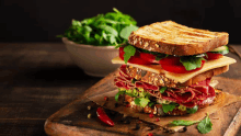 a sandwich with meat cheese and vegetables on a cutting board