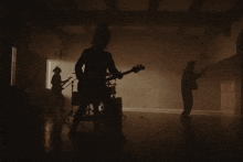 a group of people are playing instruments in a dark room .