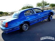 a blue lowrider car is parked on a street