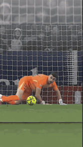 a soccer player with the number 13 on his shorts dives to catch the ball
