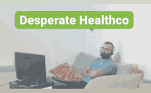 a man sits on a couch in front of a computer with the words desperate healthco on the bottom